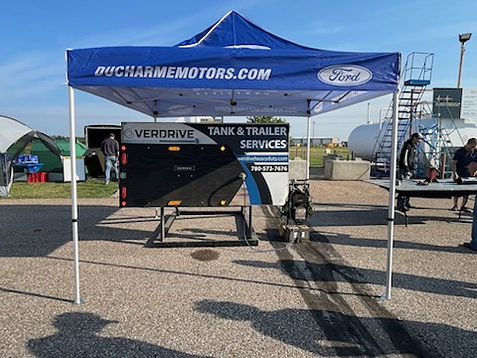 Ducharme Motors Ford tent with an Overdrive tank and trailer services banner
